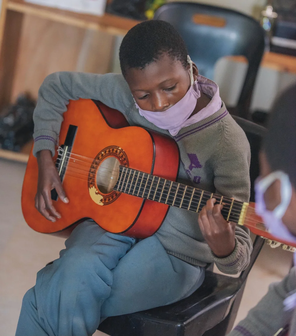 A child learning guitar